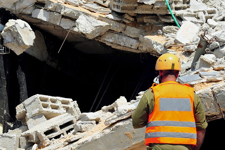 Commercial Earthquake Insurance - Closeup of a First Responder and Rubble at the Location of a Commercial Earthquake Disaster